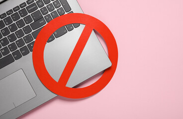 Laptop with prohibition sign on pink background