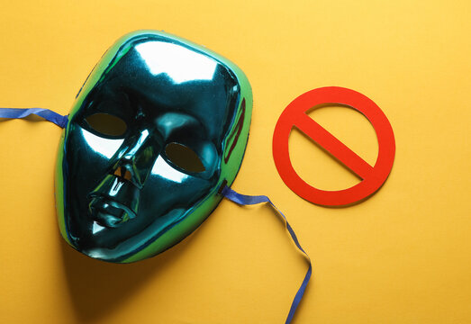 Anonymous mask with a prohibition sign on a yellow background. Cyber attack