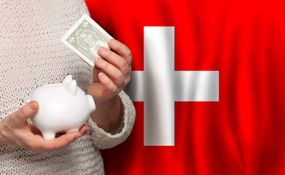 Swiss woman with money bank on the background of Switzerland flag. Dotations, pension fund, poverty, wealth, retirement concept