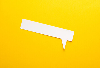 Fototapeta na wymiar Paper-cut speech bubble on a yellow background. creative layout