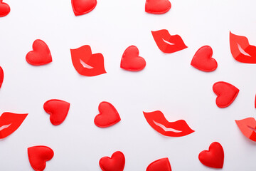 Cut out of paper a lot of red hearts with lips on a white background. Valentine's day, love concept