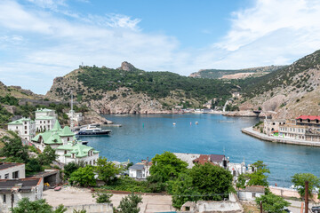 Fototapeta premium Aerial panoramic view of Balaklava bay in Crimea, mountain cliffs and sea with ships. Beautiful nature panorama landscape