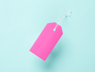Pink Blank clothing price tags or labels mockup with strings on blue background. Sale, shopping concept. Top view