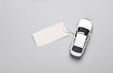 Toy car model with price tag on a gray background. Top view