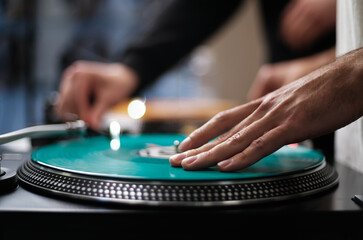 DJ plays music with vinyls and turntables. Hand of hip hop disc jockey mixing records on stage