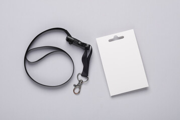 White ID card badge with black belt on gray background. Mockup for design template