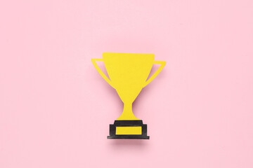 Paper-cut golden winner trophy cup on pink background. Competition, prize, award winners. Top view