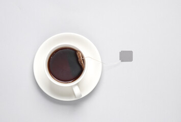 Tea cup with tea bag label on a gray background. Top view