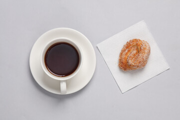 Sugar cookies on a napkin, tea cup on gray background. Top view