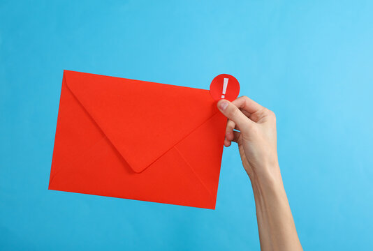 Hand holding red envelope with important notification on blue background. Social media, message, sms, subscribe notice alert and reminder.