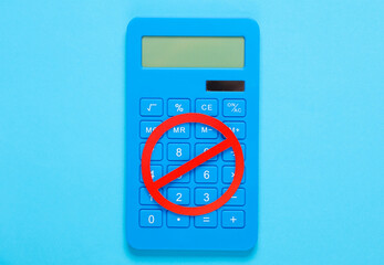Calculator with prohibition sign on blue background. Top view