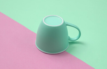 Inverted cup on a blue-pink pastel background. Minimal layout
