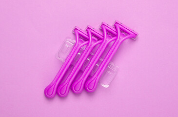 Set of disposable razors for depilation on pink background. Top view