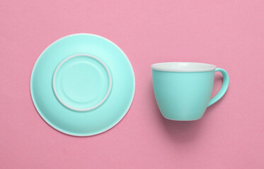 Empty cup and saucer on pink background. Top view