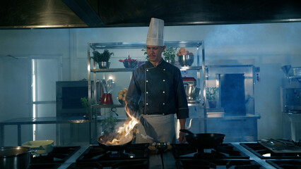 Industrial kitchen. Cooks prepare meals on the stove in the kitchen of the restaurant. The fire in the kitchen.
