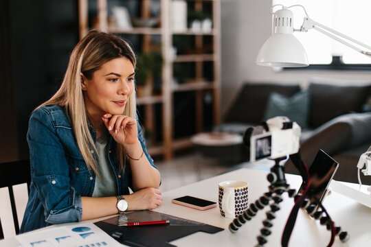 Young Business Woman Recording Video For Her Vlog Shows Papers With Graphs