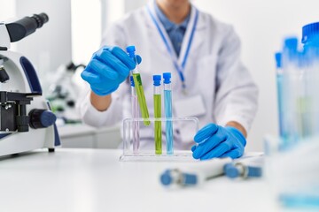 Young blond man scientist holding test tube at laboratory