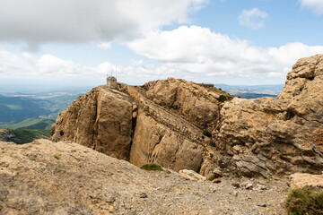 imagen de una pequeña casa en lo alto de una montaña con el cielo nublado