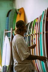 Man choosing a surfboard in a surfboard shop