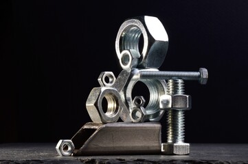 composition of nuts bolts and scraps of metal laid out on a dark background.