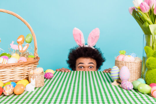 Photo of young funny hiding guy wear rabbit headband playing springtime holiday happy easter postcard celebration isolated on cyan color background