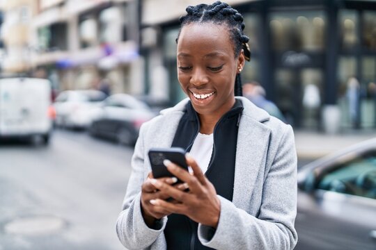 African american woman smiling confident using smartphone at street