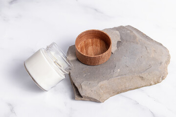 Scented candle in a glass with wooden lid on the stone. Mock up. Handmade candle