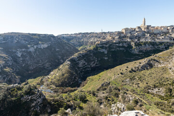 Fototapeta na wymiar Panorama of Matera, a UNESCO World Heritage Site. European Capital of Culture. View from the Murgia Park. Timeless walk inside Paleolithic caves. City similar to Jerusalem. Unforgettable journey