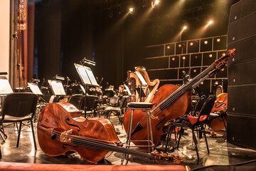 stringed musical instruments of the symphony orchestra lie on the stage before the concert...