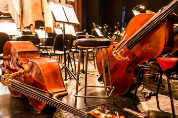 stringed musical instruments of the symphony orchestra lie on the stage before the concert...