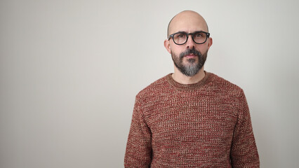 Young bald man standing with serious expression over isolated white background