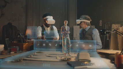 Two multi ethnic tailors in VR headsets in atelier. 3D female hologram of garment pattern. Virtual...