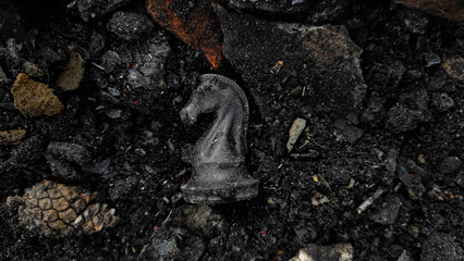 A black horse chess piece is among the rubble