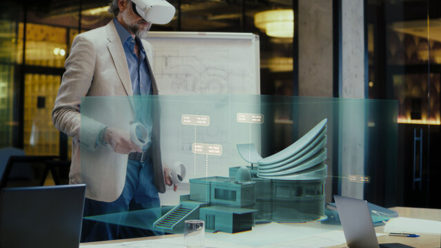 Architect designer in VR goggles presents new architecture project in modern office. Futuristic 3D hologram and visualization of building. Future digital augmented reality technologies in business.