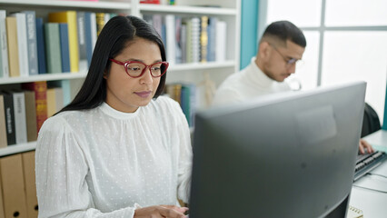 Man and woman students using computer studying at university classroom