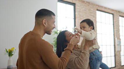 Couple and son hugging each other standing at home