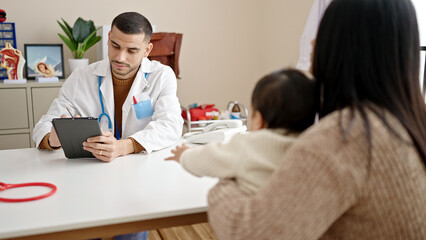 Fototapeta premium Couple and son having medical consultation writing on touchpad at clinic