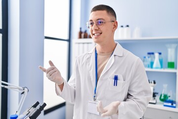 Young hispanic man scientist smiling confident speaking at laboratory