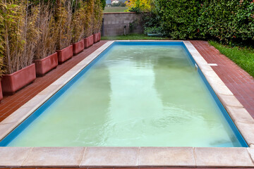 A swimming pool has white water due to shock chlorination