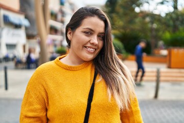 Young beautiful plus size woman smiling confident standing at street