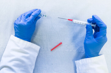 doctor with a syringe loading medication in ampoule in a medical clinic