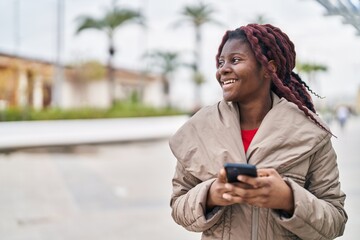 African american woman smiling confident using smartphone at park