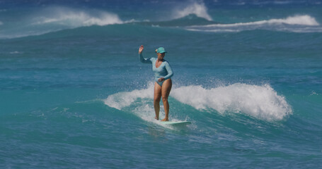 Mature woman surfer surfing ocean waves