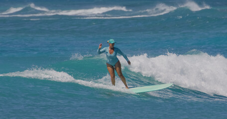 Mature woman surfer surfing ocean waves