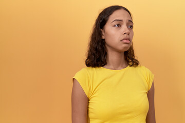 Obraz premium Young african american woman standing with sad expression over isolated yellow background