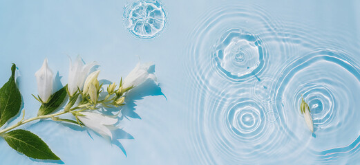 Water background with ripples on the surface and white flowers