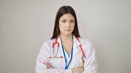 Young beautiful hispanic woman doctor standing with relaxed expression and arms crossed gesture over isolated white background