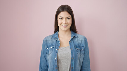 Fototapeta premium Young beautiful hispanic woman smiling confident standing over isolated pink background