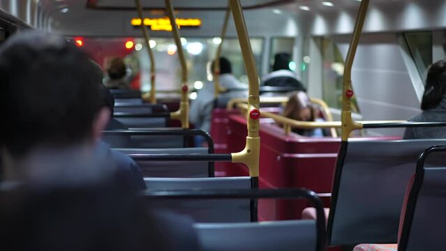 Back of bus with people commuting from work at night. Person exiting transportation in evening