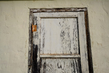 weathered white door with peeling paint
